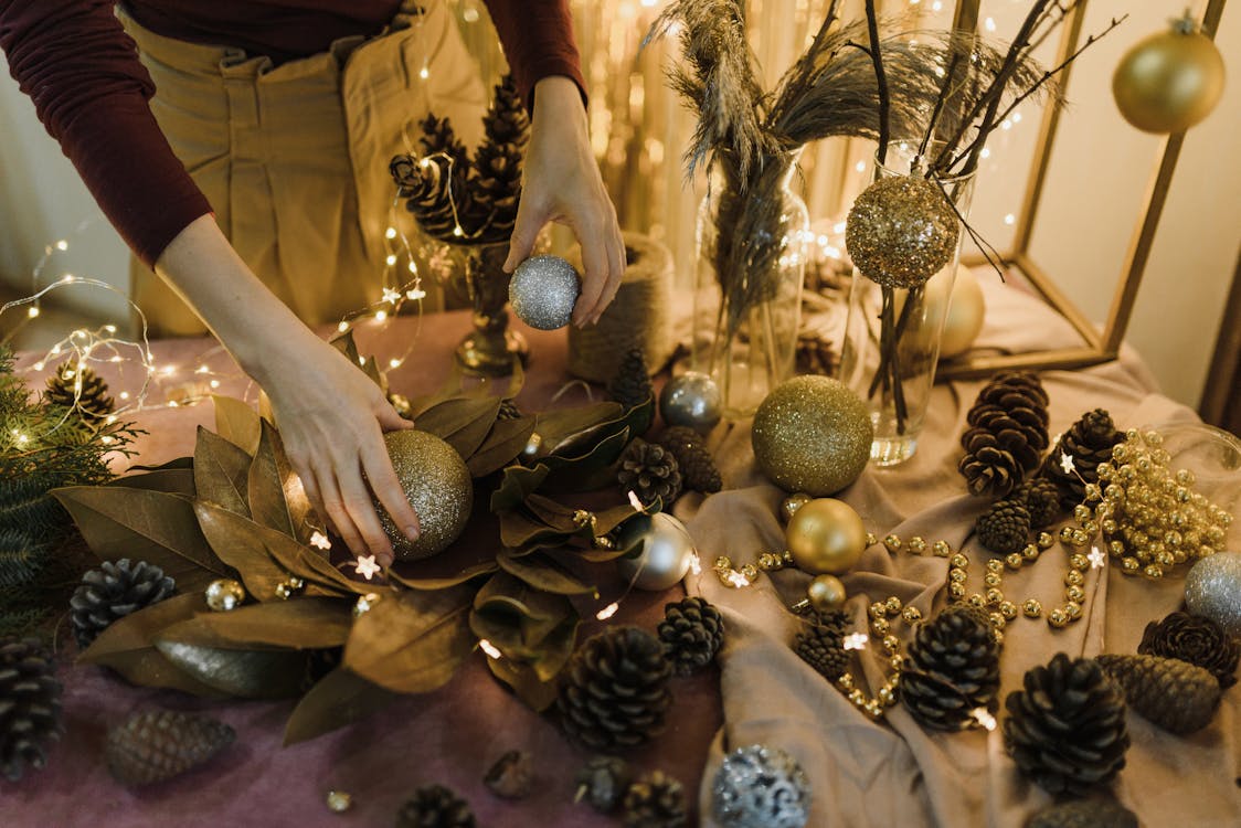A Person Setting Up Christmas Decorations on a Table