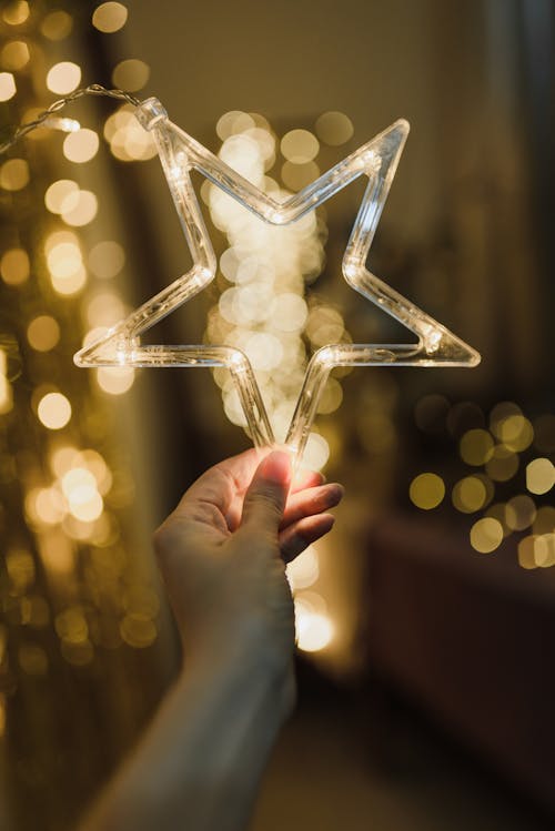 A Person Holding a Clear Star Shaped Christmas Ornament