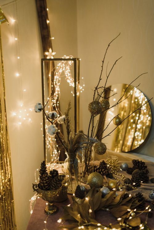 Free A cozy indoor setting with Christmas decorations, including pine cones and string lights. Stock Photo