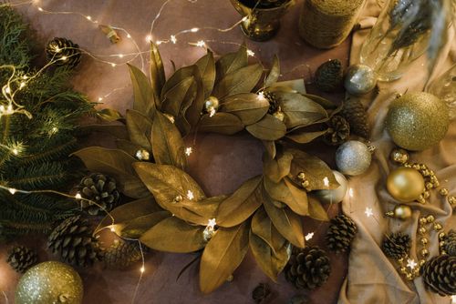 Free A beautiful Christmas wreath adorned with pinecones, baubles, and string lights for a festive holiday display. Stock Photo