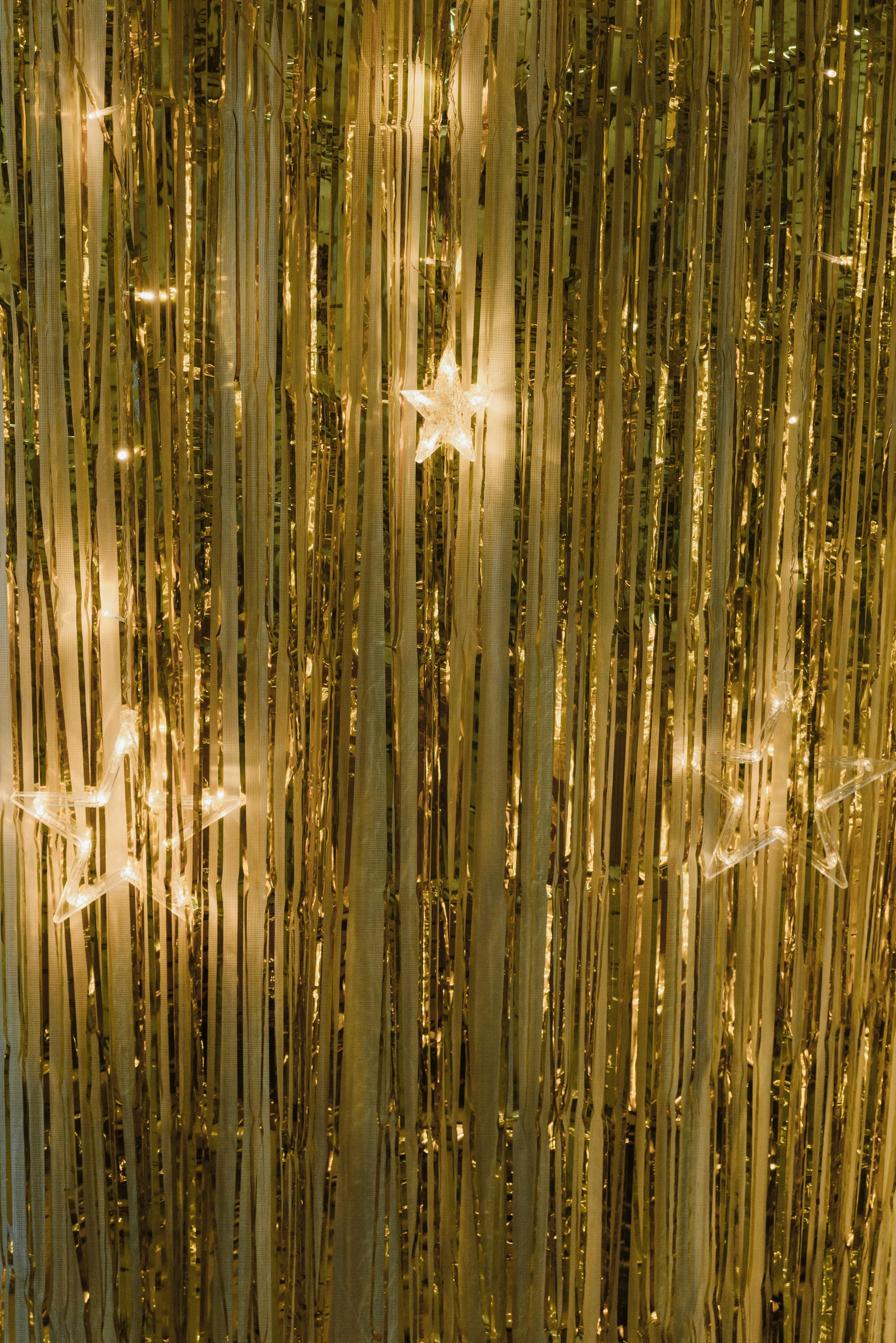 star shape lights hanging on a gold curtain at christmas