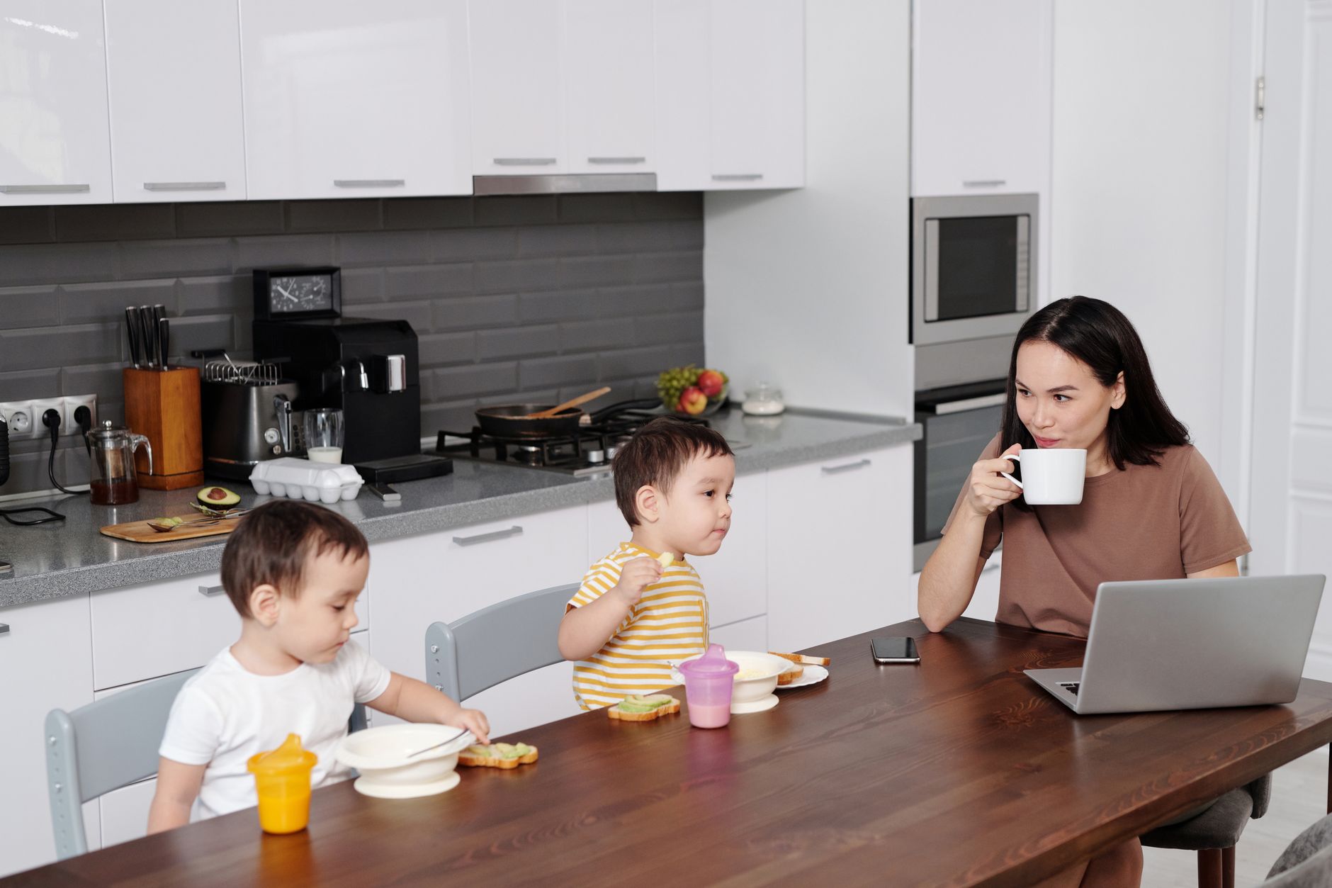 Family using a simple phone basket and timer to keep dinner device free while chatting with a toddler
