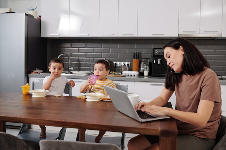 Busy Woman In The Kitchen With Children