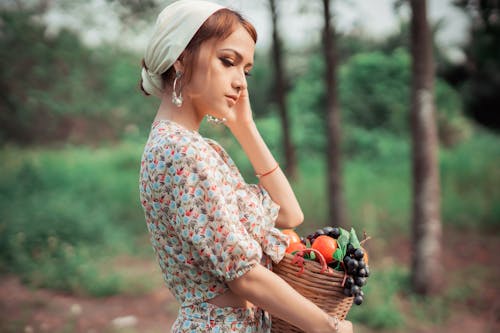 Tender woman with basket of fruits