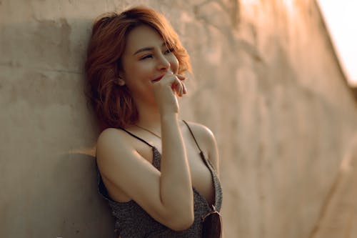 Happy woman leaning on stone wall