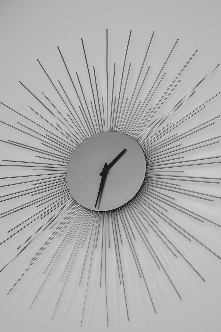 Shiny Clock With Metal Beams On A Wall