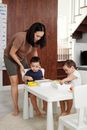 Mother and Her Children Playing at the Kitchen