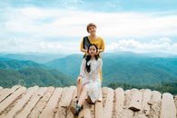 Happy young ethnic women having fun on house roof in highland