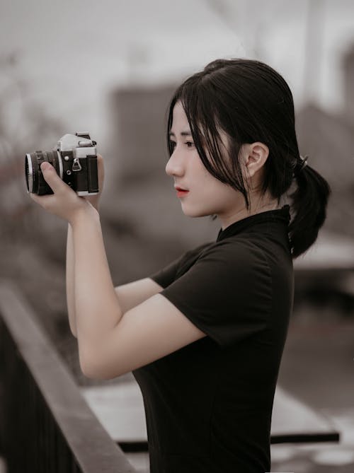 Young woman with photo camera on street