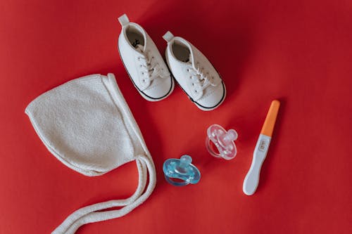 Close-Up Shot of Pregnancy Test Near Baby's Things