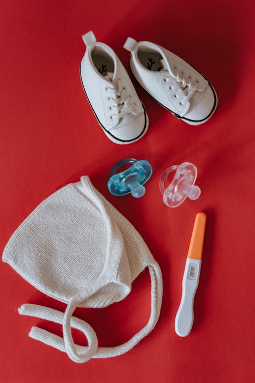 Close-Up Shot of Pregnancy Test Near Baby's Things