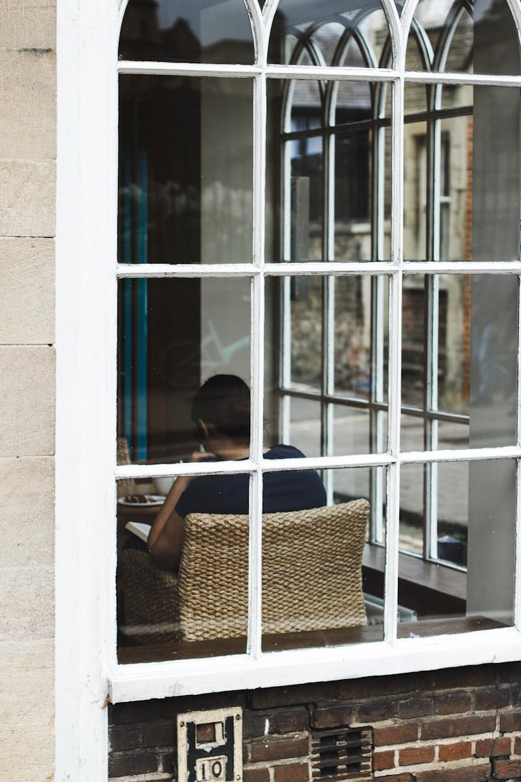 Unrecognizable Person Sitting In Lobby Behind Building Window