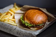 Burger With Lettuce and Fries on Brown Wooden Chopping Board