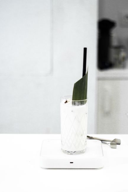 A refreshing cold drink with a leaf garnish in a tall glass, perfect for a summer day.