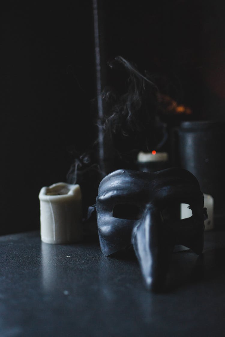 Black Beak Like Mask Placed On Table In Darkness