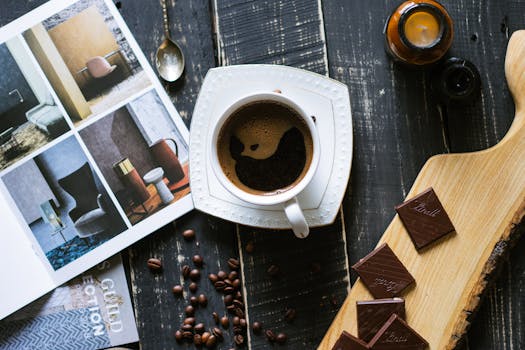 Elegant coffee scene with chocolate pieces and a design magazine, featuring modern interior inspiration.