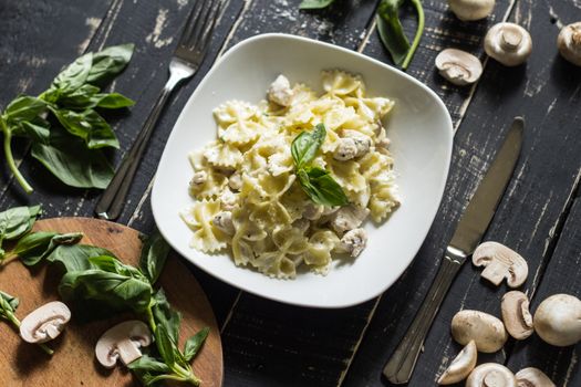 A tempting plate of creamy mushroom pasta garnished with fresh basil, shot from above.