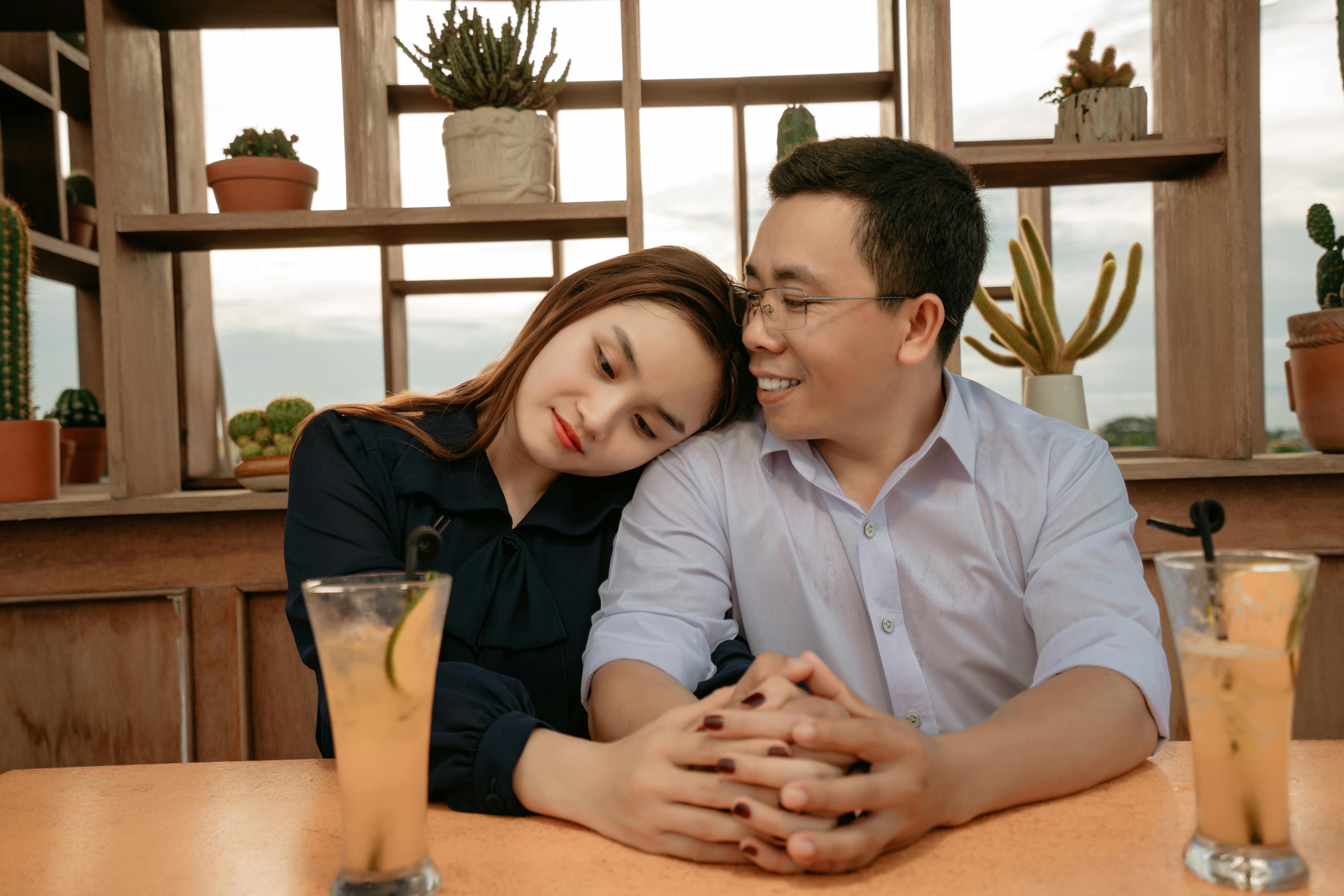 Asian couple having date in cafeteria with drinks · Free Stock Photo