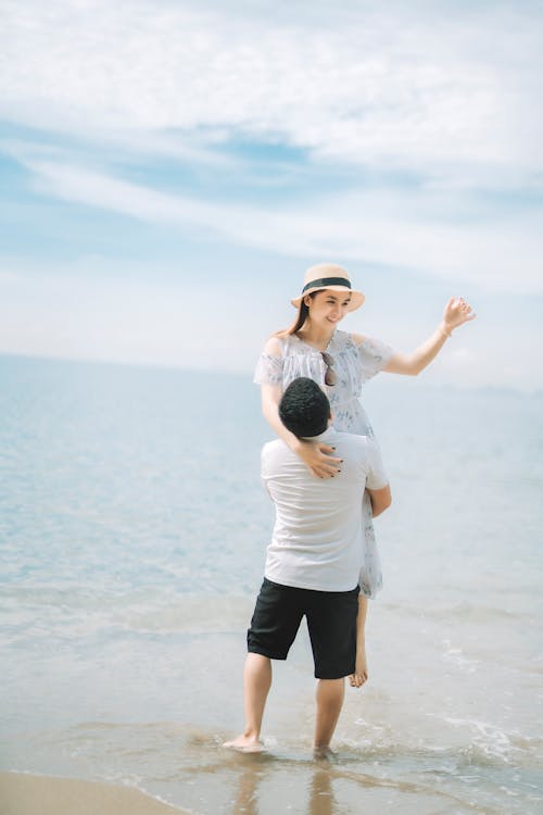 Couple hugging on sandy coast near sea