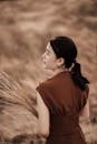 Elegant Asian woman with plant sprigs in countryside field
