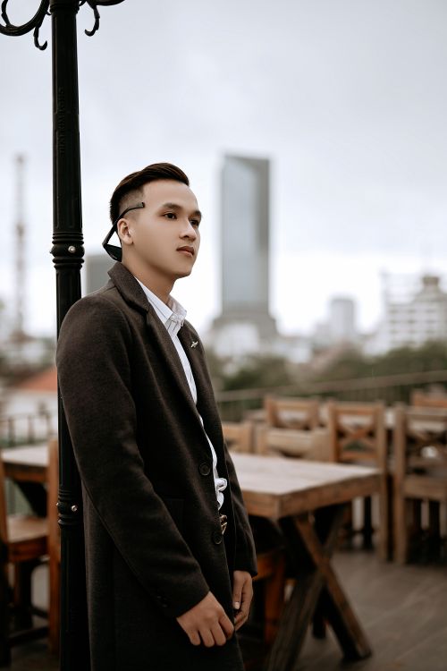 Free Side view of contemplative young well dressed ethnic male with sunglasses and modern haircut looking away on cafeteria veranda Stock Photo