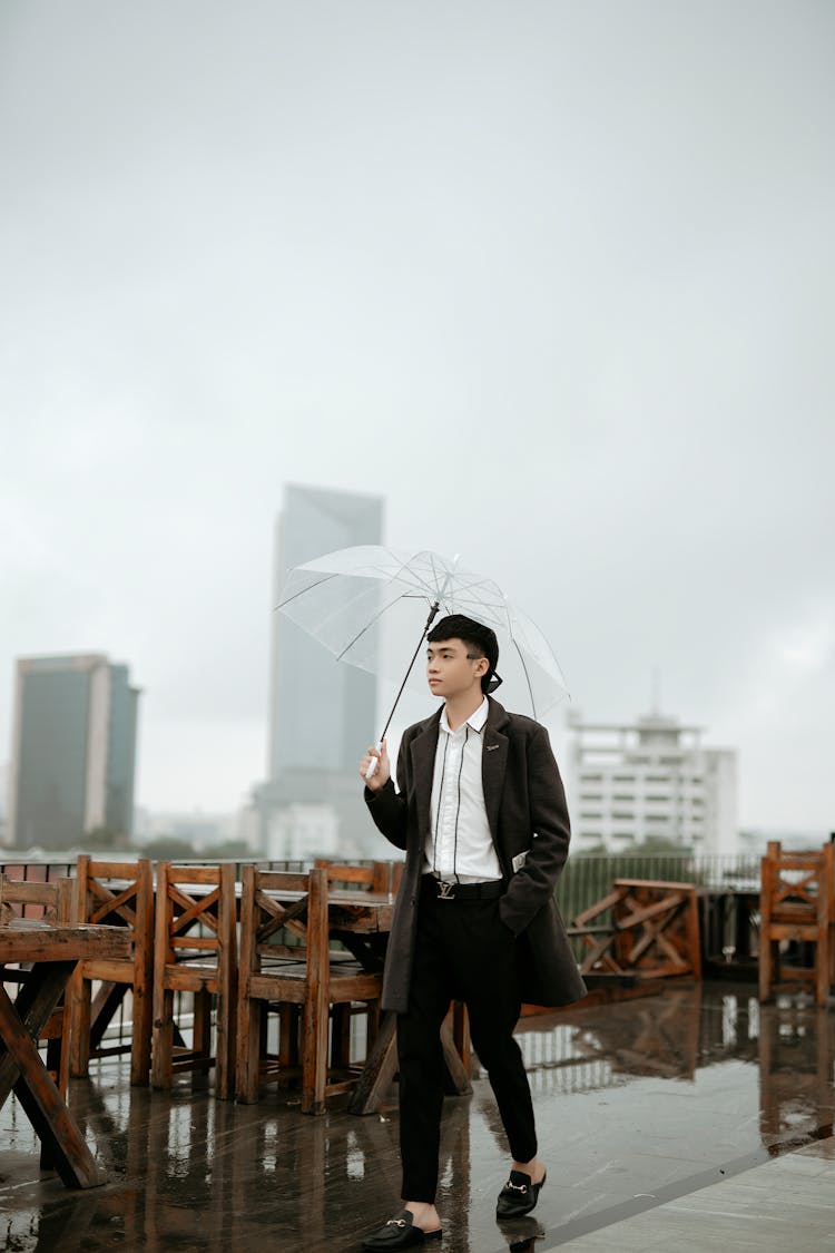 Stylish Asian Man Walking On Cafe Terrace In City