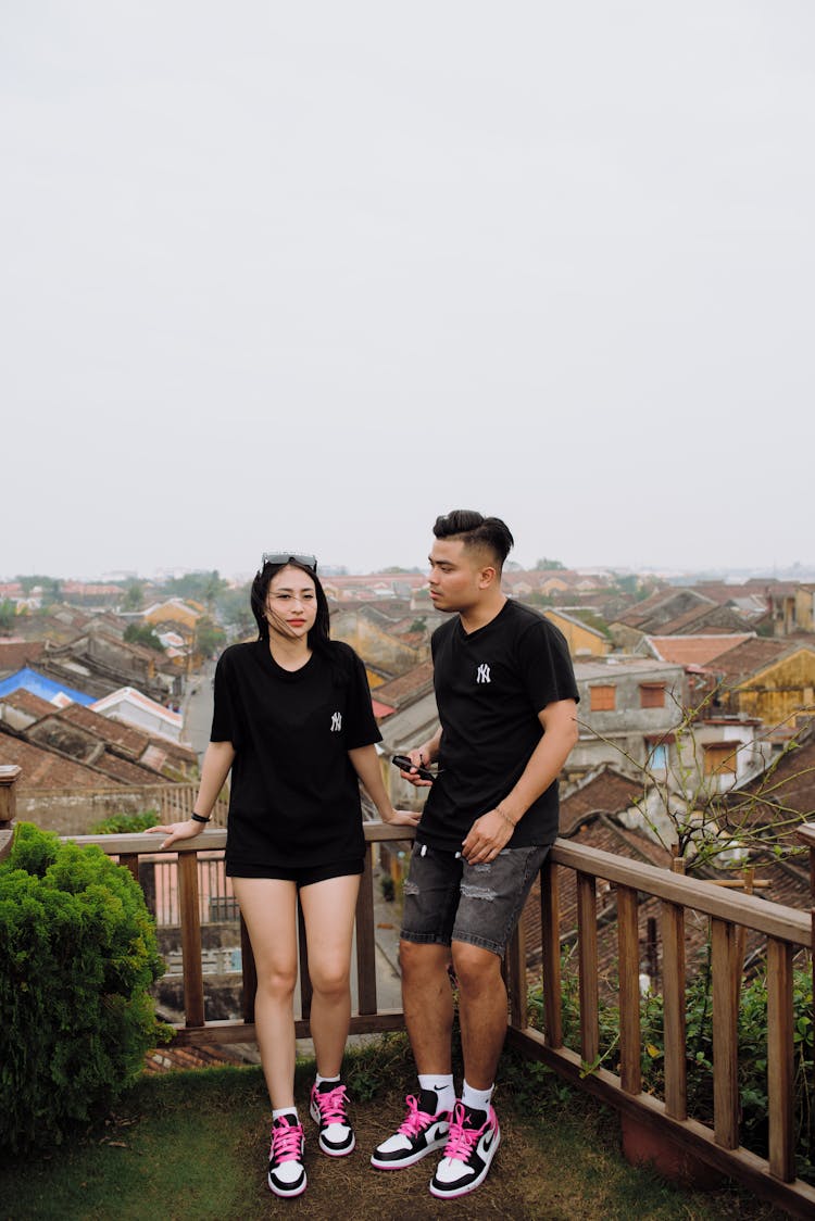 Trendy Asian Couple On Terrace Against Old Buildings