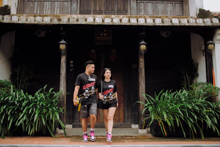 Content Asian Couple Leaving Wooden House