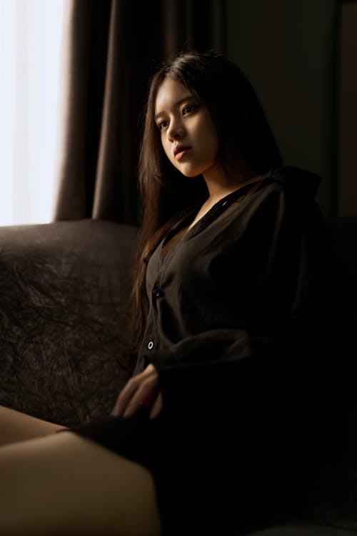 Gorgeous Asian woman resting on comfortable couch