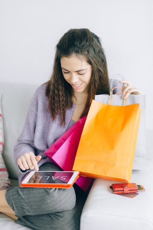 How to Choose the Right Credit Card for Your Lifestyle 3 A picture of a person using a tablet and holding shopping bags