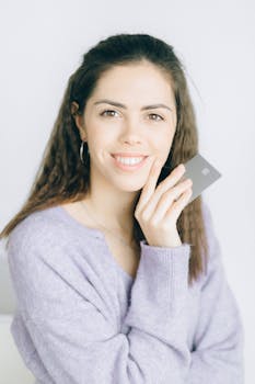 Financial independence concept with a smiling woman holding a credit card indoors.