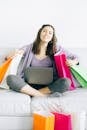 Woman Sitting on Couch with Shopping Bags