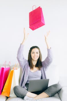 Smiling woman throwing shopping bag while online shopping at home.