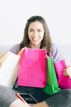 Happy woman sitting with vibrant shopping bags, enjoying a sale.