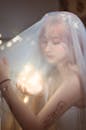 Romantic Asian bride in veil illuminated by garland