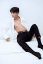 Sensual Asian male with naked torso lying on bed