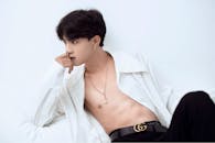 Asian model with naked torso in stylish outfit looking away