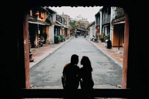 Back view of anonymous couple looking at each other on Chinese street in daytime