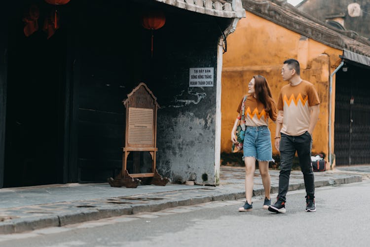 Young Asian Couple Walking On Old Street