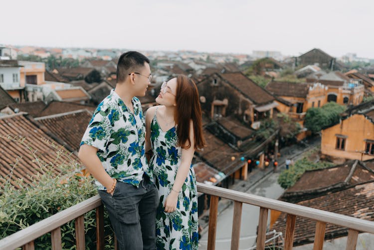 Happy Asian Couple In Eyeglasses On Urban Balcony