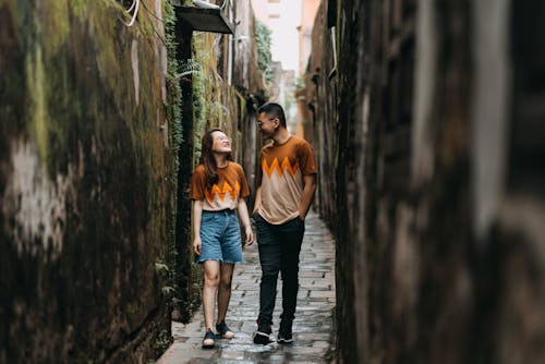 Ethnic couple walking on narrow city street