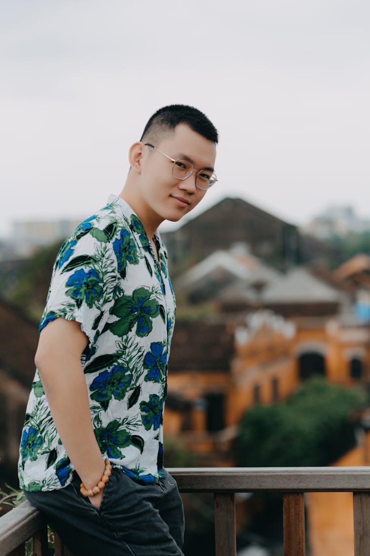 Cheerful Asian Man Standing On Balcony