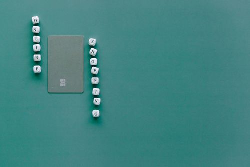 Free Green background with bank card and letter blocks spelling 'Online Shopping'. Stock Photo
