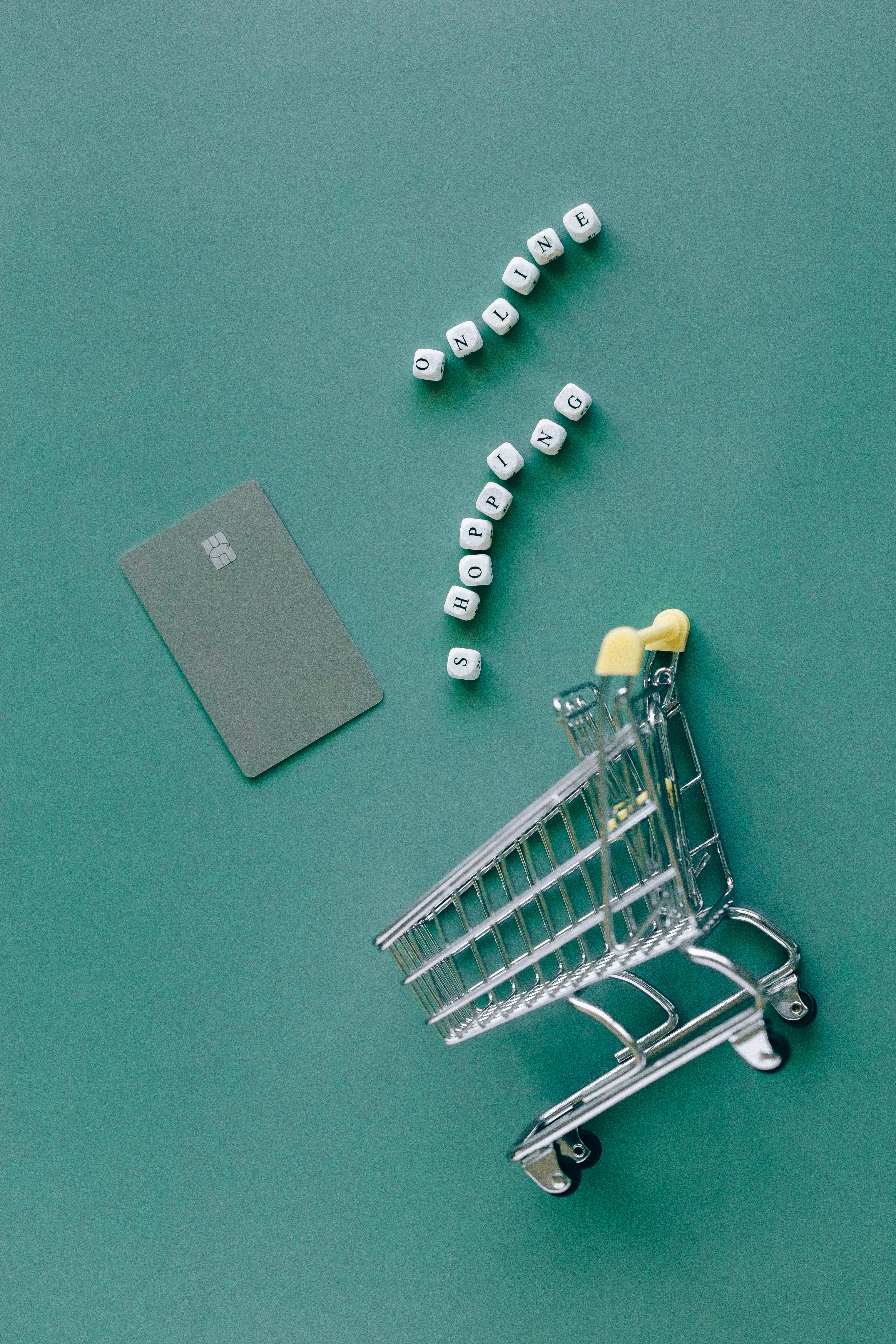 silver shopping cart on green background