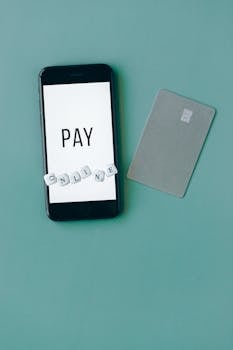 Vertical shot of a smartphone and card promoting online payment with a green background.