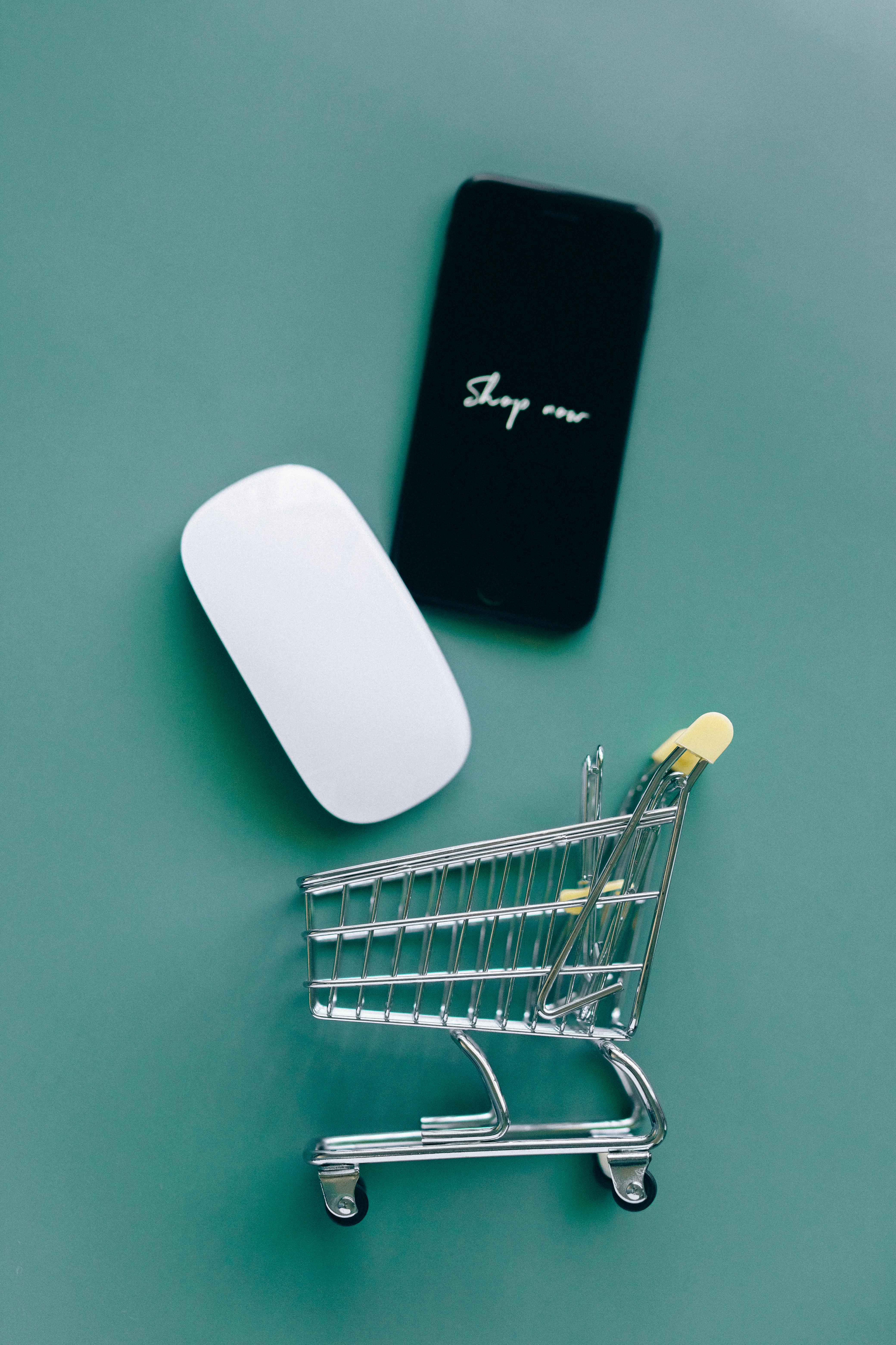 a smartphone and a miniature shopping cart