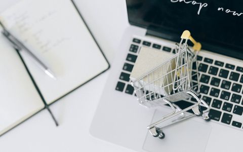 Carrito de la compra en miniatura sobre un portátil