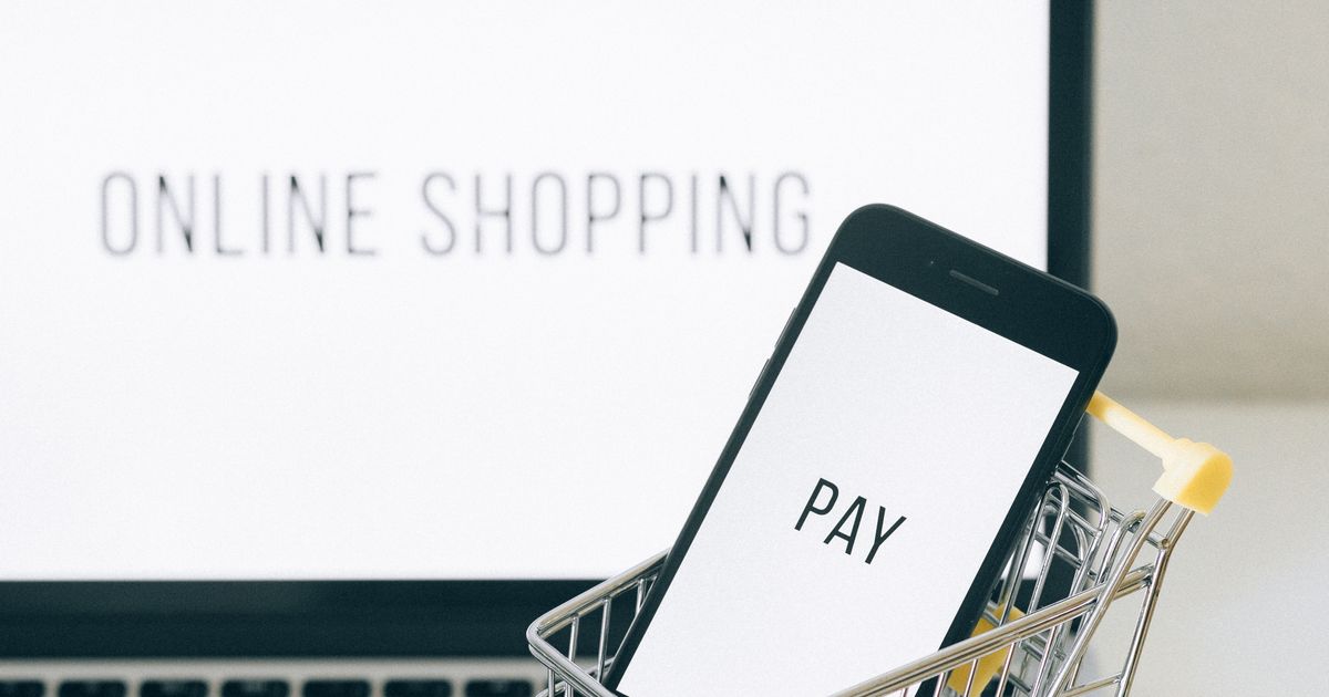 Smartphone dans un chariot miniature, symbole d'achat en ligne