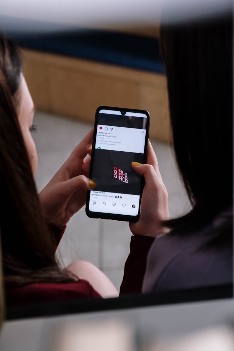 Close-Up Shot Of A Person Looking At A Picture On Instagram