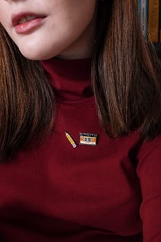 Stylish woman wearing a burgundy top with a retro cassette badge. Modern fashion portrait.